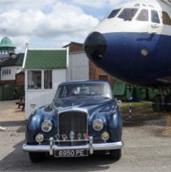 Bentley Continental S1 Flying Spur in front of the nose of a Vickers VC10 aircraft.